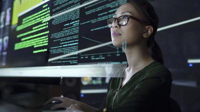 Asian woman looking at data in code