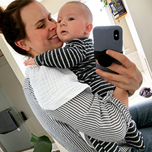 Accounting student Hanna M. holds her newborn son and smiles.