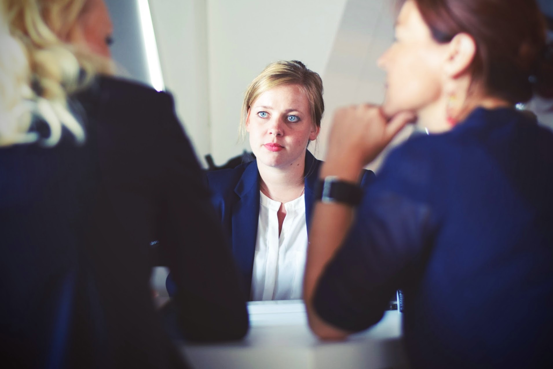 A manager listens to two female employees to promote conflict resolution