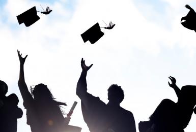 Sillhouette of graduates throwing caps in the air 