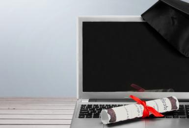 Laptop with diploma and graduation cap 