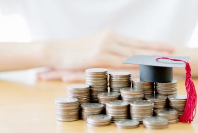 Stacks of quarters topped with mini graduation cap 