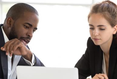 Manager and employee discussing career path and looking at laptop