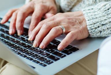 Hands typing on laptop keyboard