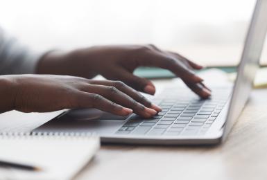 Photo of hands typing on a laptop