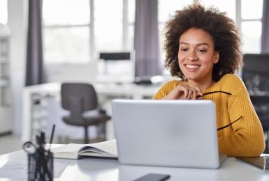 Female content strategist looking at laptop in office