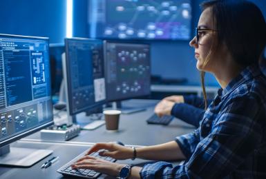 Female cybersecurity professional working on a computer.