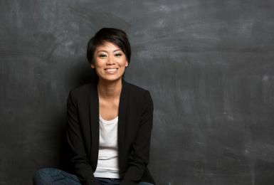 Student sitting on floor in front of chalkboard