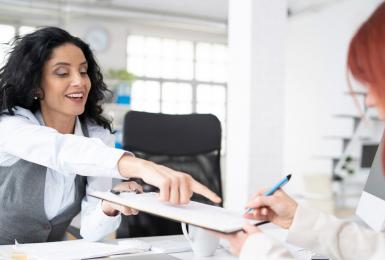 Woman helping employee fill out form on clipboard