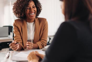 Middle-aged CPA works with a client at her desk.
