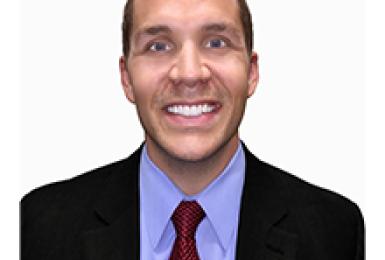 Champlain student Ben Walkington smiles at the camera against a white background.
