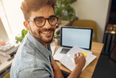 Portrait of male student working on online coursework.