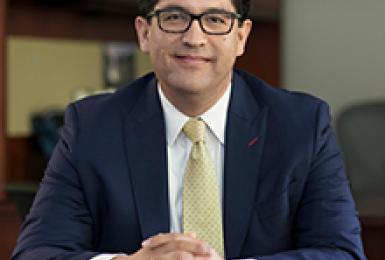 Image of Alex Hernandez seated in office smiling at camera.
