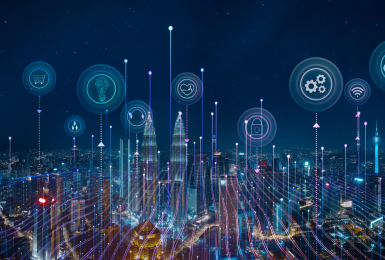 Night skyline with smart devices and icons representing Internet of Things concept