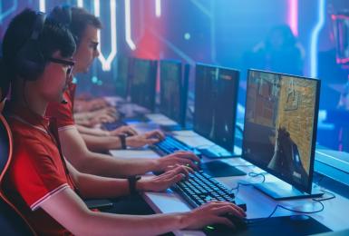 Several professional PC gamers sitting at a table playing online games
