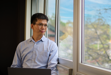 Asian male looking out of window