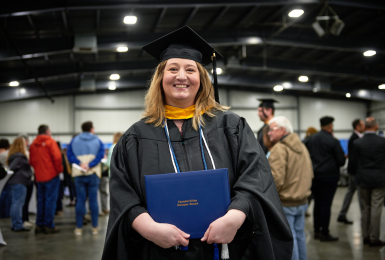 Female graduate dressed in graduation regalia smiling portrait