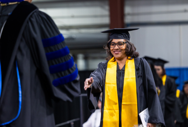 Female graduate walking across stage during commencement ceremony