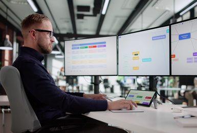A marketing manager sits at a desk in an open office