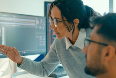 Two IT professionals looking at a computer screen.