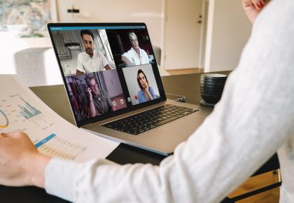 Manager holding video call with remote team on laptop