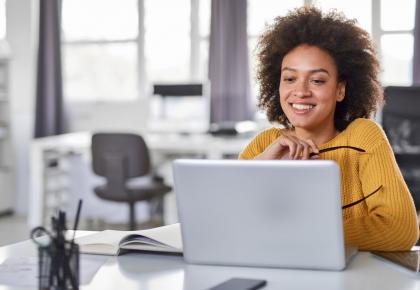 Female content strategist looking at laptop in office