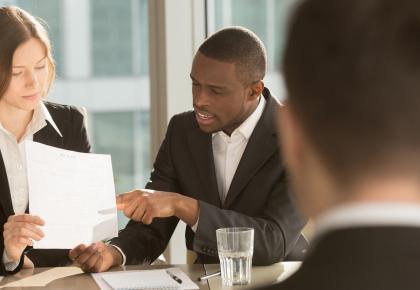 Professionals in an interview, reviewing a resume with online credentials