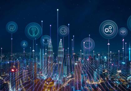 Night skyline with smart devices and icons representing Internet of Things concept.