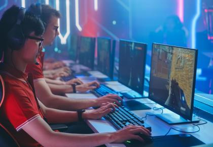 Several professional PC gamers sitting at a table playing online games 