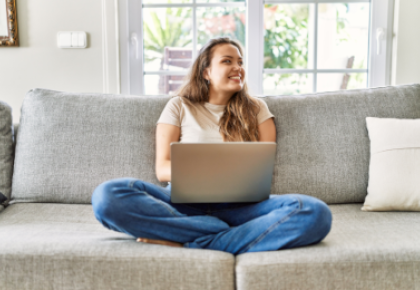 young woman sitting on couch with computer