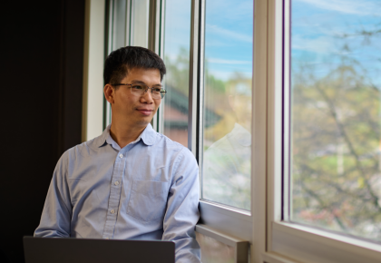 Asian male looking out of window