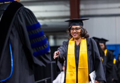 Female graduate walking across stage during commencement ceremony