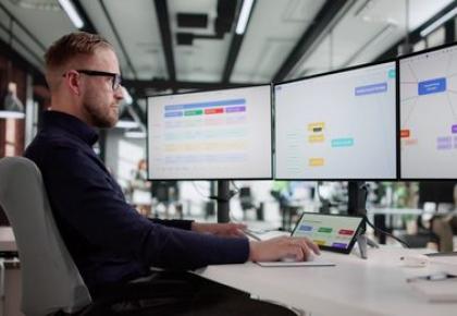 A marketing manager sits at a desk in an open office