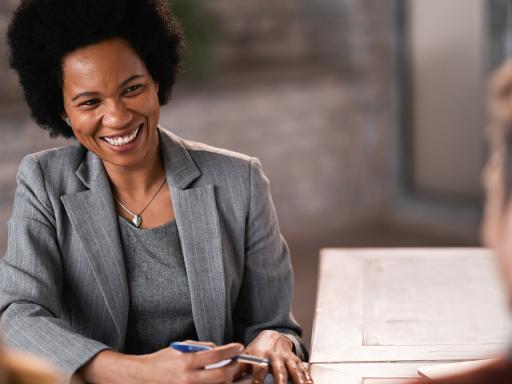 Woman leading meeting at a table with pen and paper