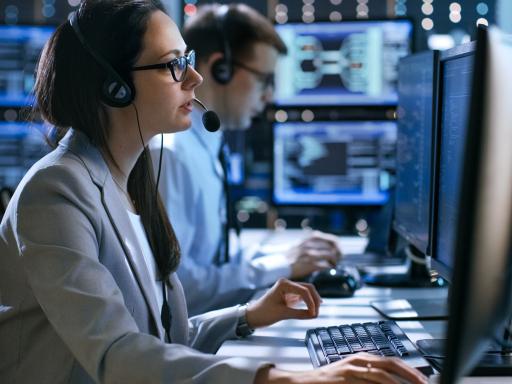 Cybersecurity professional in a control room on a computer