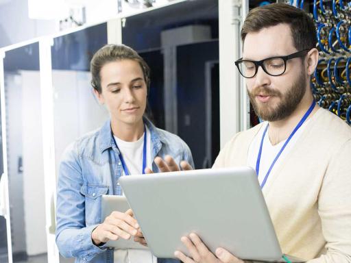 Online information security professionals looking at a computer in a server room