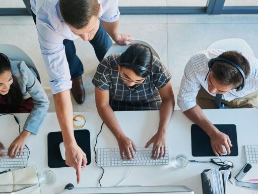 Manager and team members looking at a computer screen