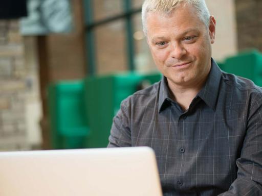 Adult Male Cybersecurity Student working on laptop