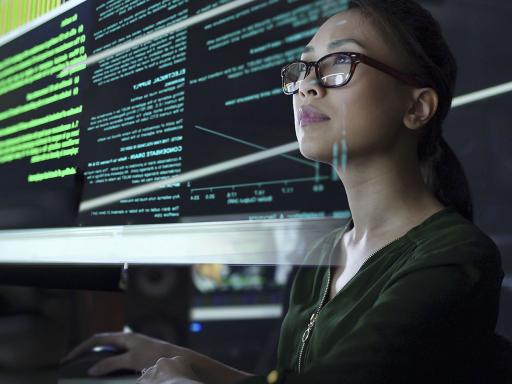 Asian woman looking at data in code