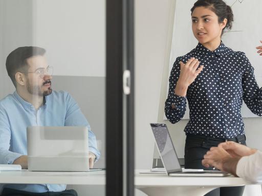 woman leading a meeting with men sitting at a table