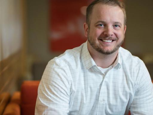 Male student on office setting smiling at camera