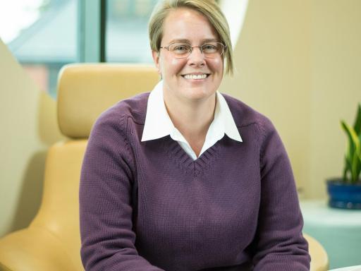 Female student in office lounge smiling at camera