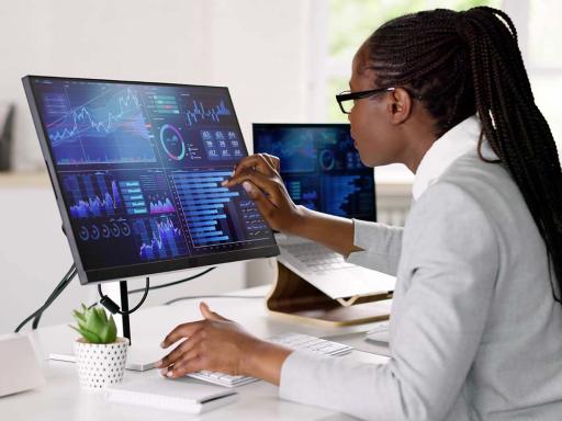 african american woman with long hair at a monitor with data on it