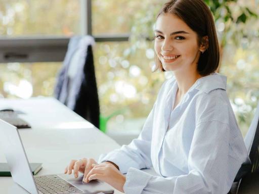 Public administration woman smiling at a desk with a laptop