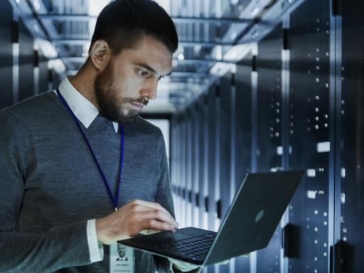 Man with laptop in server room