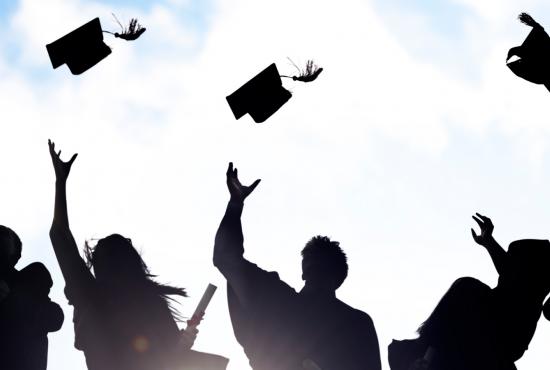 Sillhouette of graduates throwing caps in the air