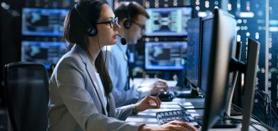 Cybersecurity professional in a control room on a computer