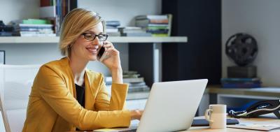 Female student talking and smiling on the phone with Champlain support team member