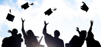 Sillhouette of graduates throwing caps in the air 