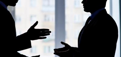 Silhouette of two professionals engaged in conflict resolution.